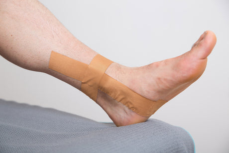 Man wearing zinc tape on ankle for support