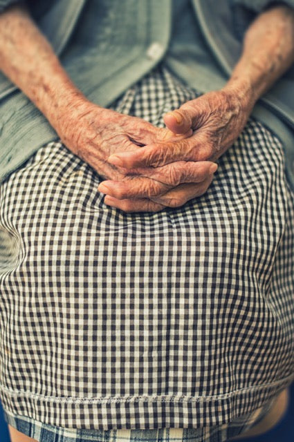 Older person's hands resting in their lap. Photo by Danie Franco on Unsplash