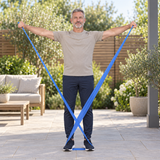 Man exercising outdoors with a blue resistance band