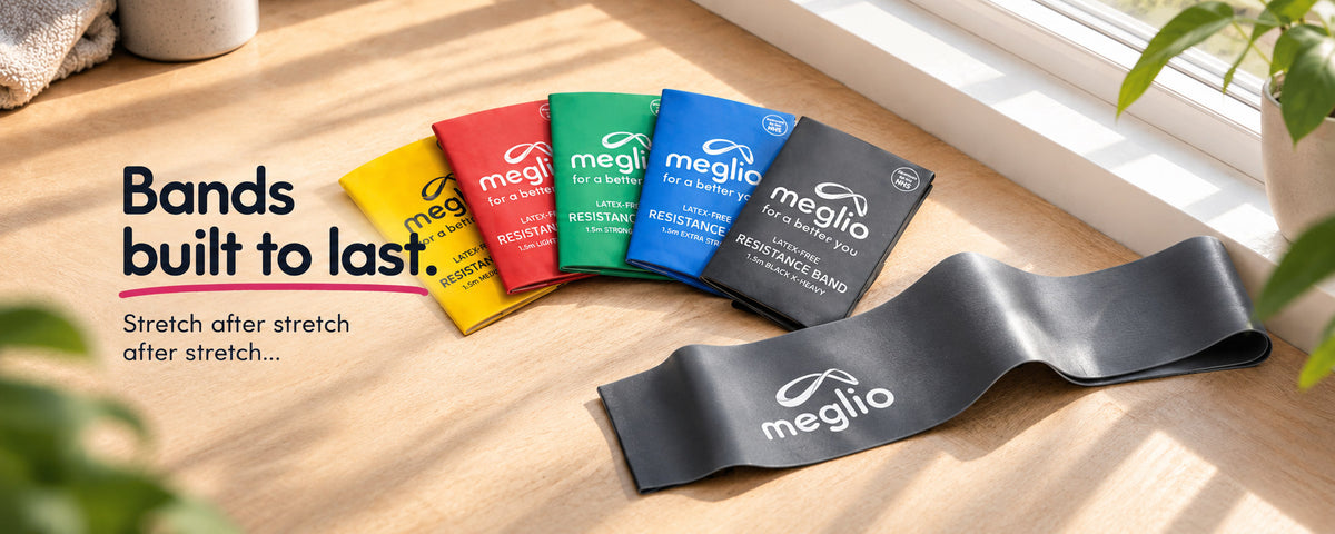 Meglio latex-free 1.5m resistance bands in five colours with a black X-Heavy band unrolled on a desk. Bands built to last.